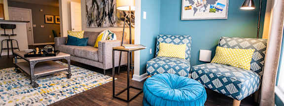 A living room with a blue chair and ottoman.