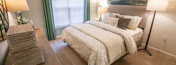 A bedroom with a large bed and a painting on the wall.