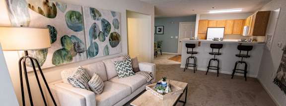 A living room with a white couch and a lamp.