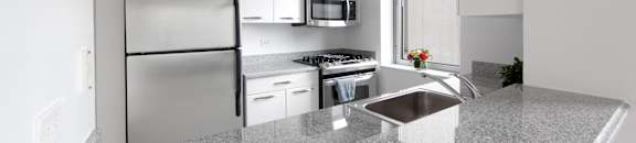 A modern kitchen with granite countertops and stainless steel appliances.at 'The Metropolis', New York, NY