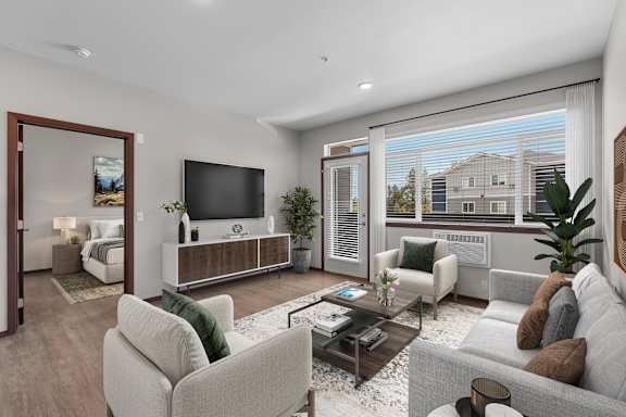 A modern living room with a grey sofa, a white armchair, a coffee table, and a television.