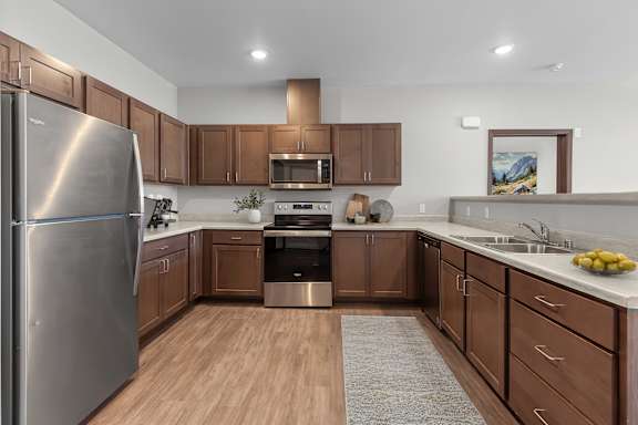 A modern kitchen with wooden cabinets and stainless steel appliances.