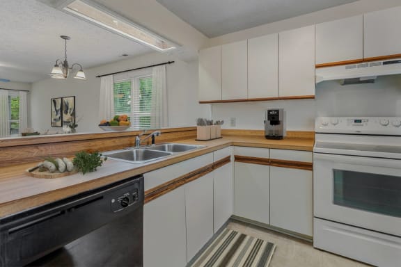 a kitchen with white cabinets and stainless steel appliances and a sink