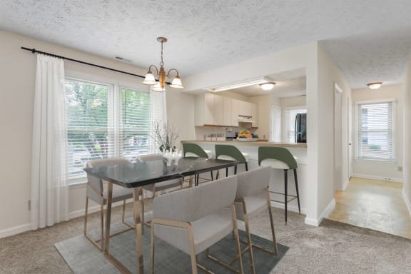 a dining room with a table and chairs and a kitchen