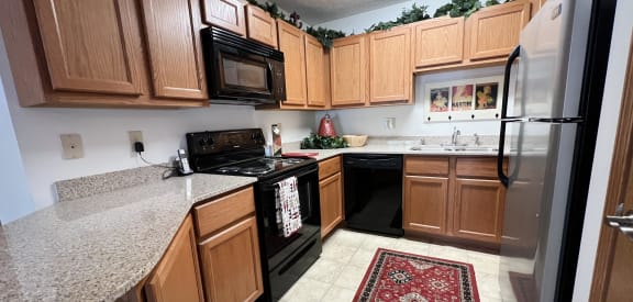 a kitchen with wood cabinets and black appliances