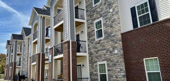 a row of apartments with brick and stone walls at Parkway Trails, Florence, KY, 41042