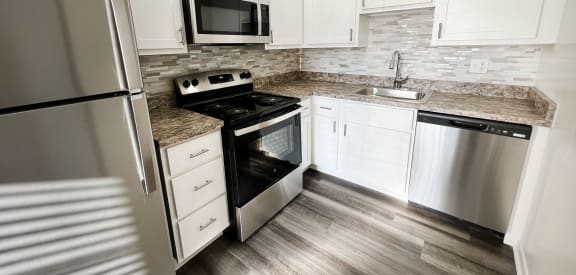 a kitchen with stainless steel appliances and white cabinets at Walnut Creek Townhomes, Cincinnati, OH