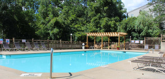 a swimming pool with chairs and a wooden fence around it