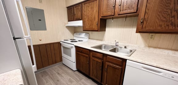 a kitchen with white appliances and wooden cabinets  at Devou Village, Ft. Wright, Kentucky