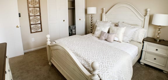 a bedroom with a white bed and a closet