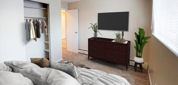 a bedroom with a large bed and a dresser with a tv on the wall