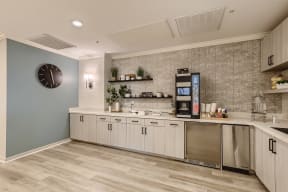 a kitchen with white cabinets and a stainless steel refrigerator