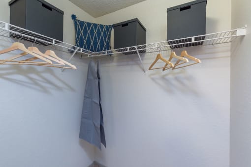 a closet with three hangers and three boxes on the wall