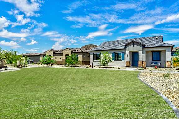 A row of houses with a green lawn in front.