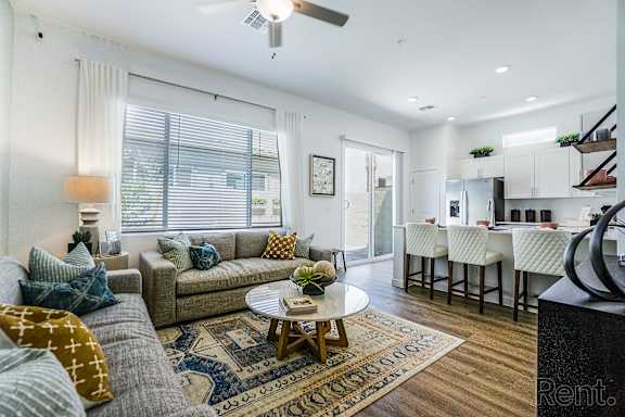 A living room with a couch, a coffee table, and a rug.