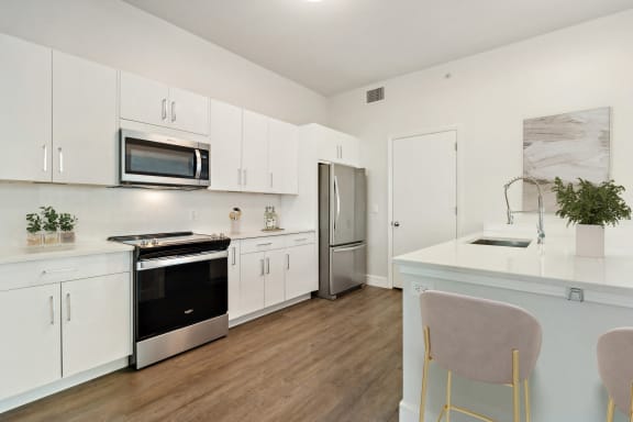 a modern kitchen with white cabinets and stainless steel appliances at Paramount on Lake Eola, Orlando, 32801