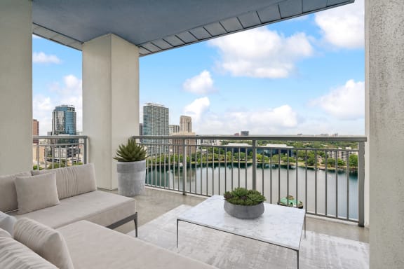 a living area with a couch and a coffee table and a balcony overlooking a river at Paramount on Lake Eola, Orlando