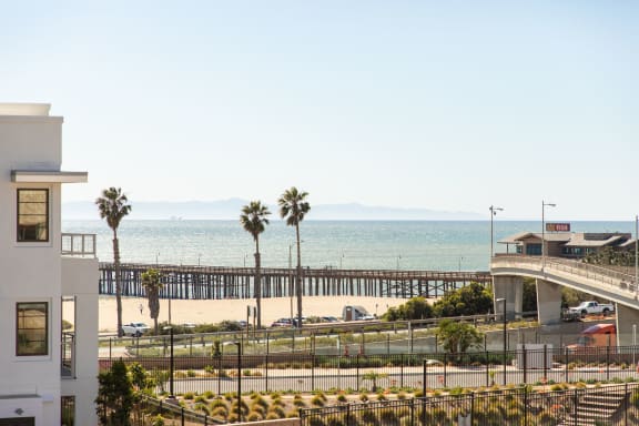 a view of the beach and the pier from the balcony of a condo