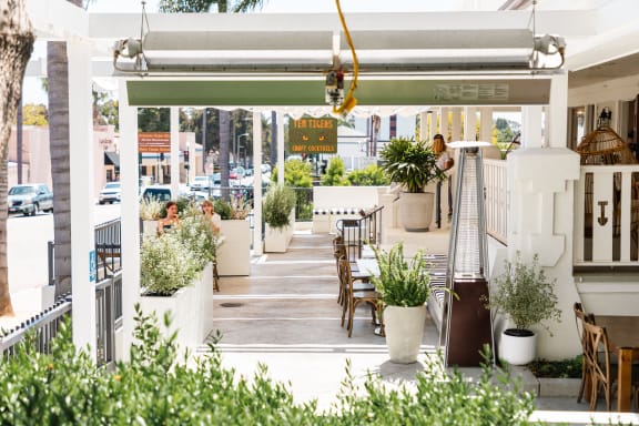 a patio with tables and chairs and potted plants