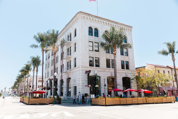 a large white building with palm trees in front of it
