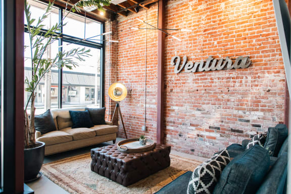 an exposed brick wall in a living room with a couch and a table