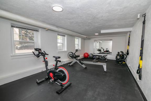 A room with a stationary bike and a rowing machine.