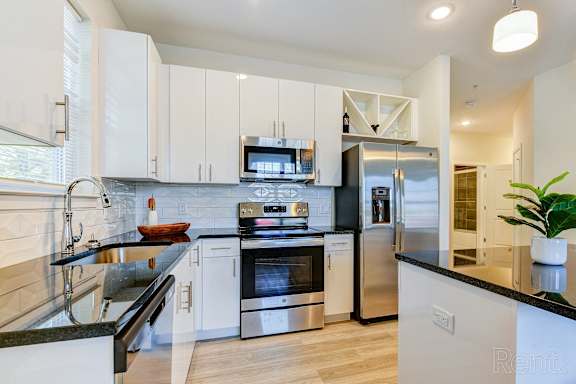 A modern kitchen with stainless steel appliances and white cabinets.