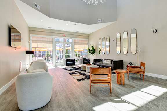 A living room with a white chair and wooden furniture.