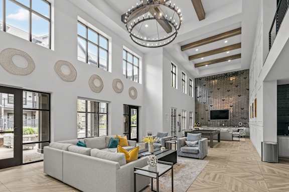 A modern living room with a large chandelier and a fireplace.