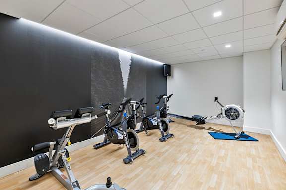 A room with exercise equipment and a wooden floor. at Trio Newton Apartments, Massachusetts