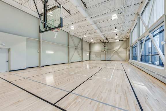 A basketball court with a wooden floor and a basketball hoop.