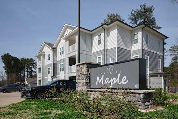 A large building with a sign that says "Park at Maple".