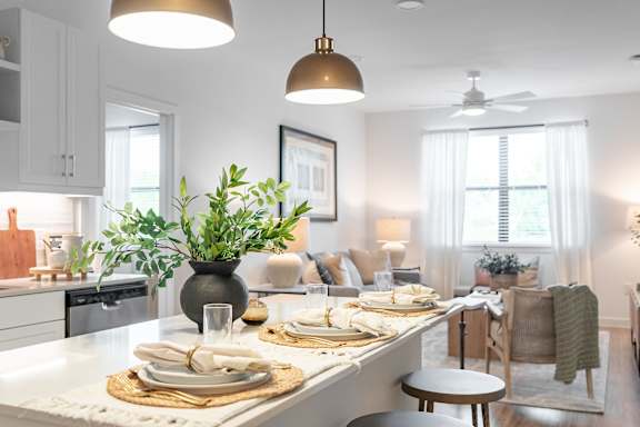 A modern kitchen with a dining table set for two.