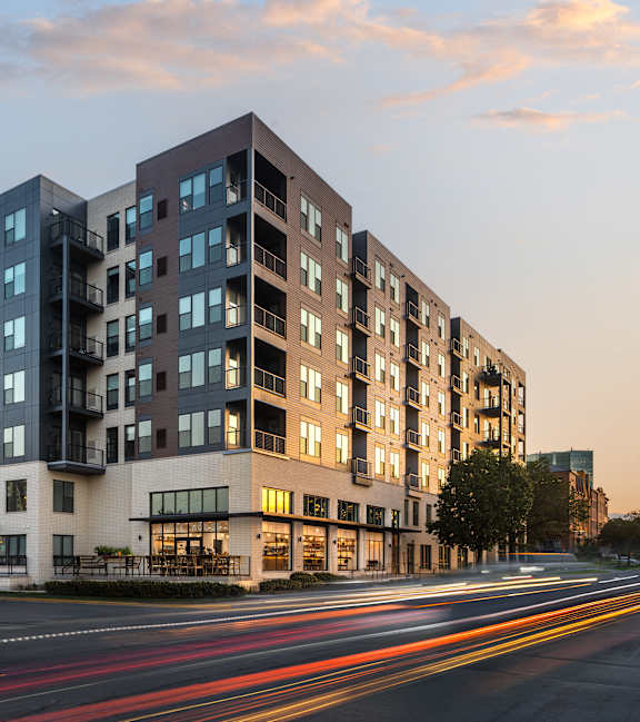 A modern apartment building with a street in front of it.