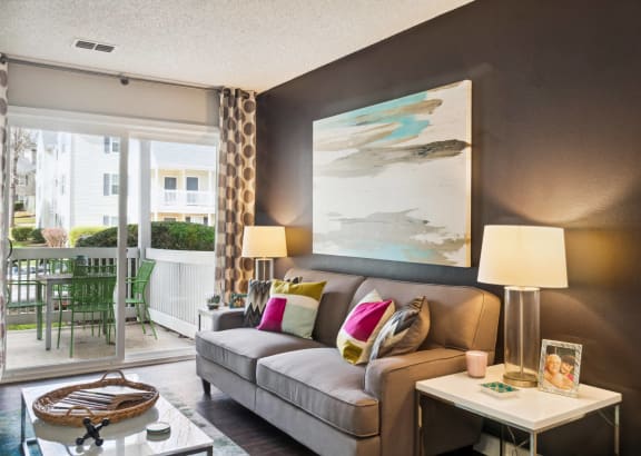 a living room with a couch and a coffee table and a door to a balcony