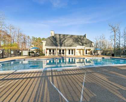 a swimming pool with a house in the background