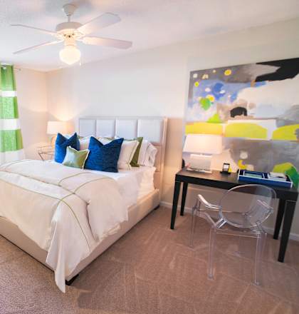 A bedroom with a bed, desk, and chair.