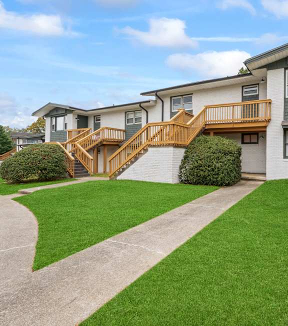 A residential building with a green lawn in front.