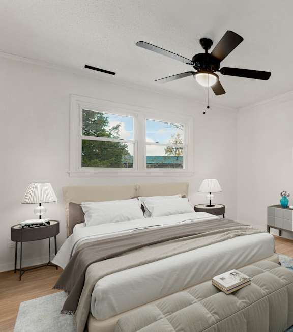 A bedroom with a large bed and a ceiling fan.