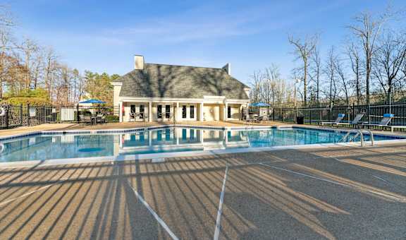 a swimming pool with a house in the background at Ashton Creek in Chester, VA 23831