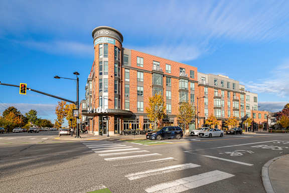 A street view of a city intersection with cars and a traffic light. at Trio Newton Apartments, Massachusetts