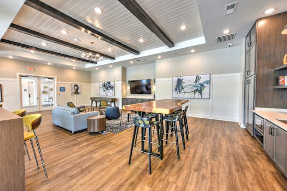 A modern room with a wooden floor and a bar area.