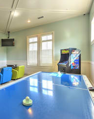 a game room with a ping pong table and a video game