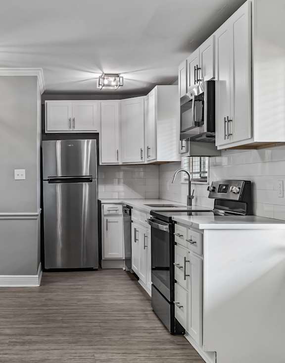 A kitchen with white cabinets and a stainless steel refrigerator. at The Sanctuary, Tallahassee, FL