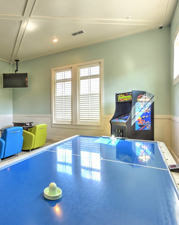 a game room with a ping pong table and a video game at Palm Bay Club, Jacksonville, FL