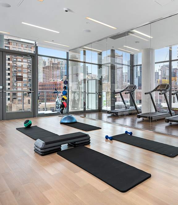 A gym with a view of the city outside the windows.