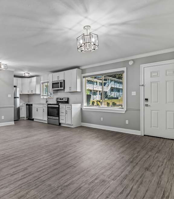 A spacious kitchen with white cabinets and a wooden floor. at The Sanctuary, Tallahassee, FL, 32304
