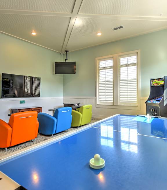 A pool table in a room with a red wall and a window.