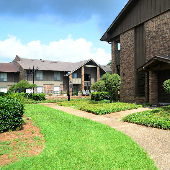 A brick building with a green lawn in front.