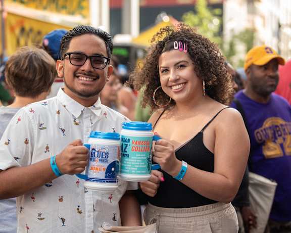 a man and woman holding cans of beer in a crowd of people at Center Square Lofts West, Allentown